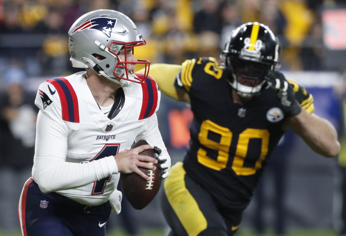 New England Patriots quarterback Bailey Zappe (4) runs the ball as Pittsburgh Steelers linebacker T.J. Watt (90) chases during the third quarter at Acrisure Stadium. New England won 21-18.